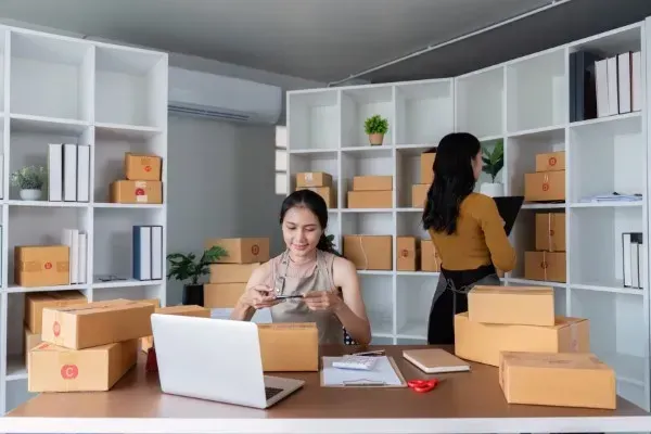 Dos empresarias gestionan el alto volumen de pedidos, impulsado por una estrategia de SEO para tienda online efectiva.